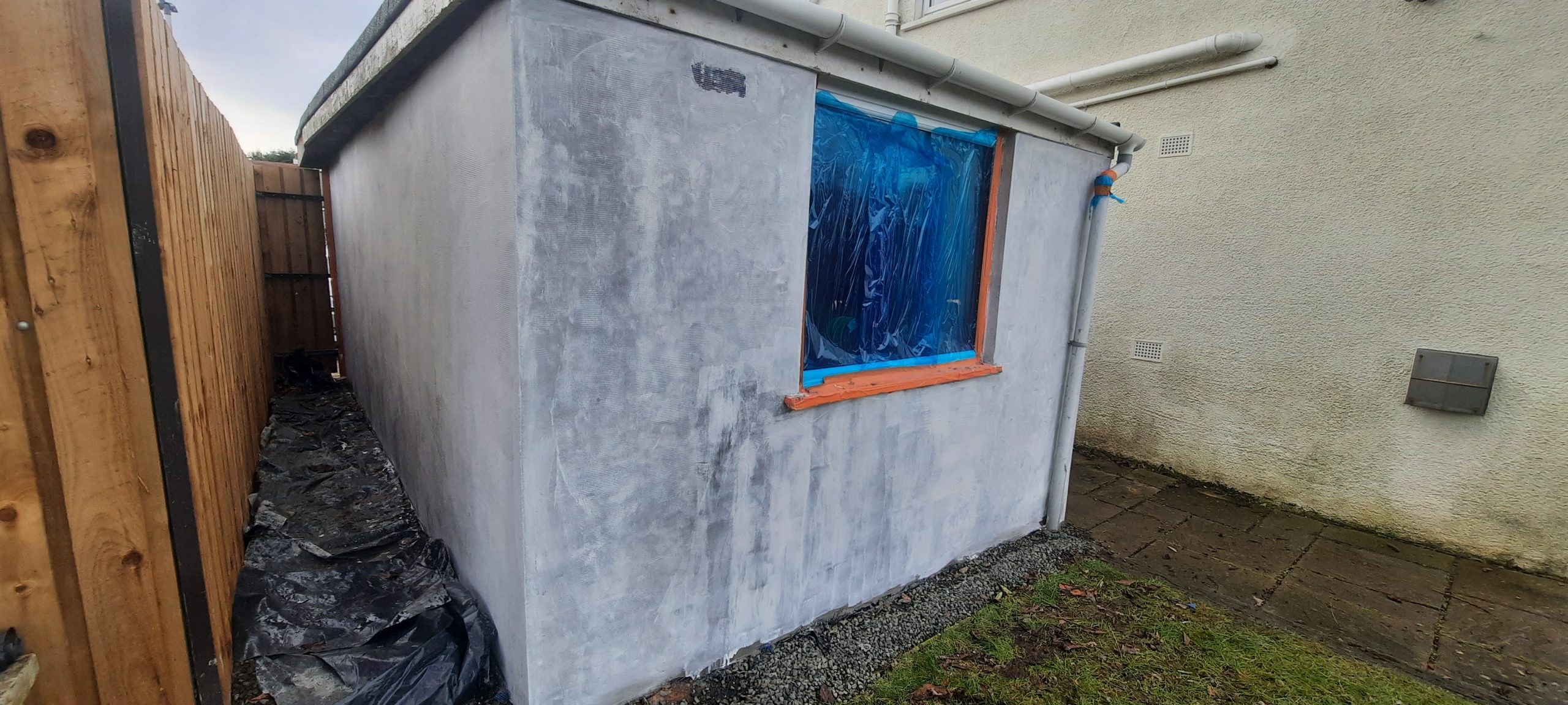 roughcasting Edinburgh on garage wall with window