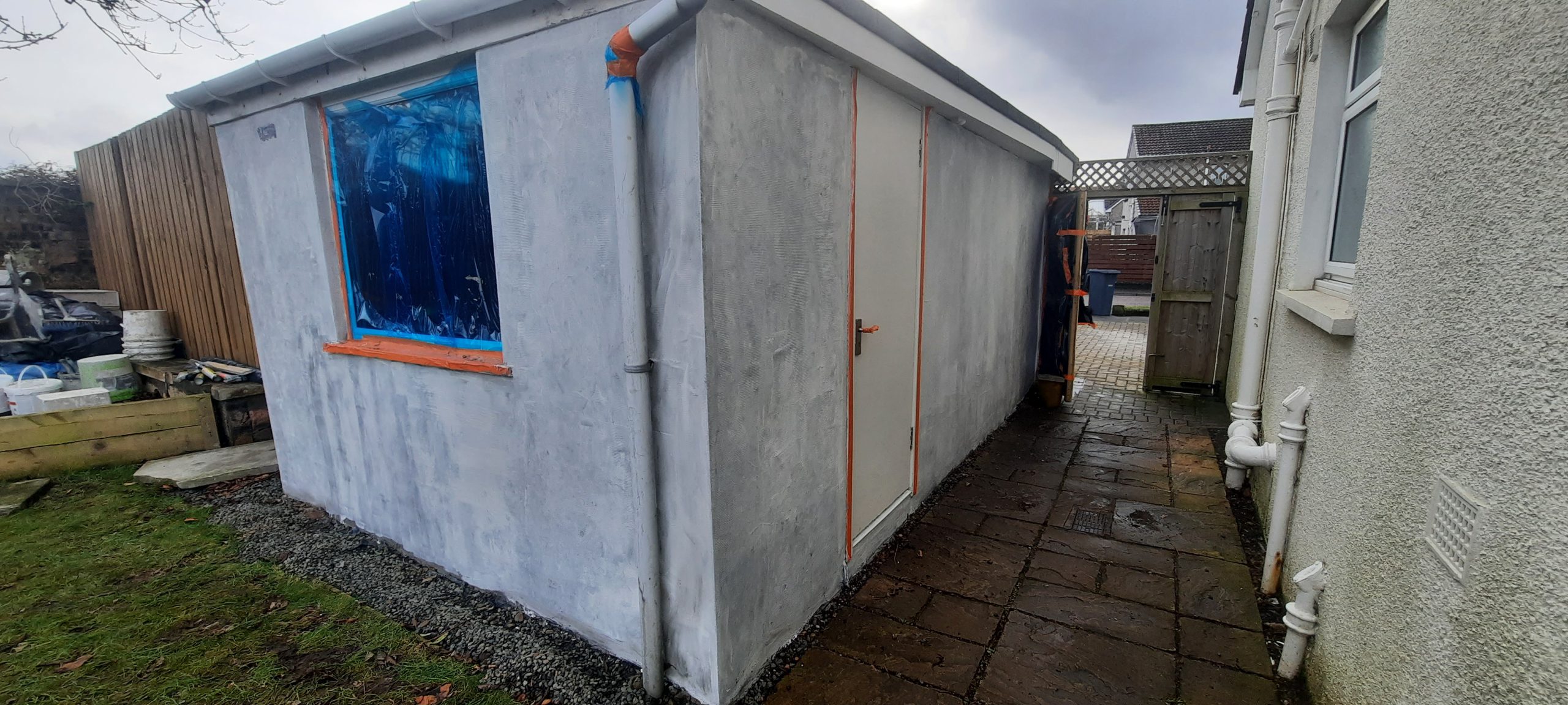 roughcast render repair along garage side wall