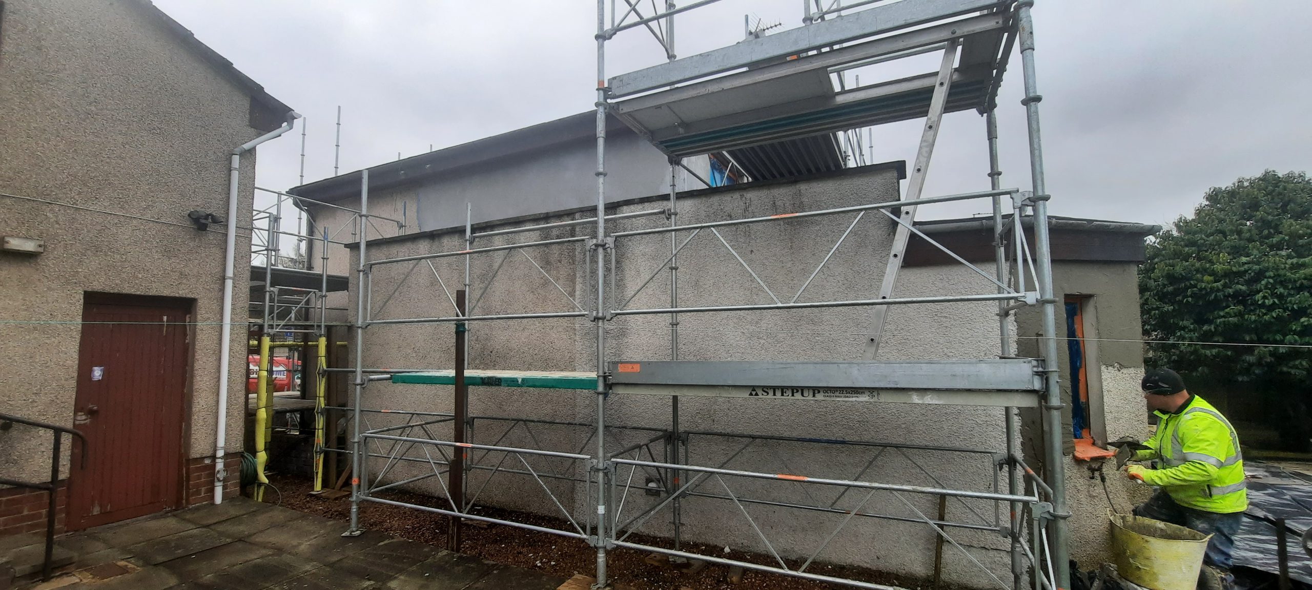 roughcast repair behind green safety netting