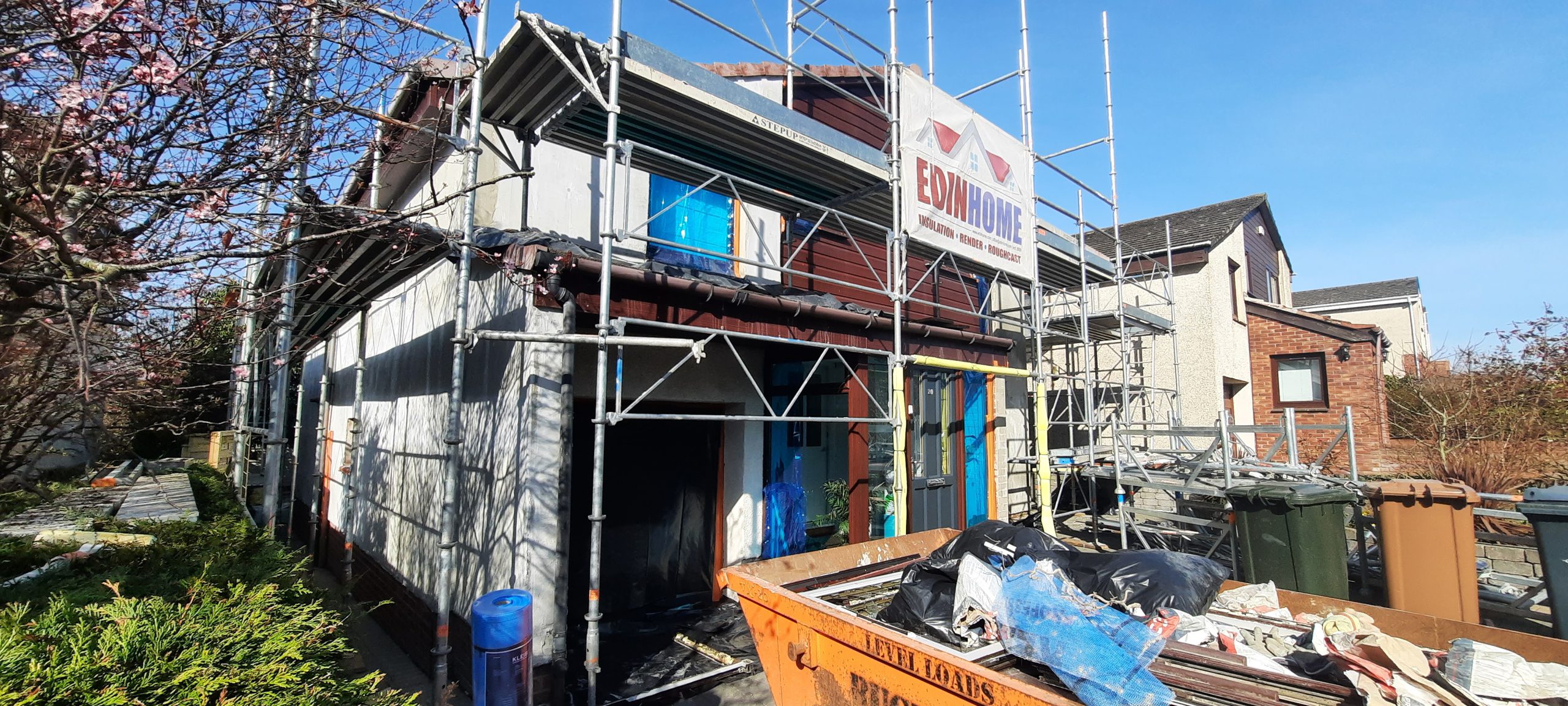 roughcast render repair with building site waste nearby