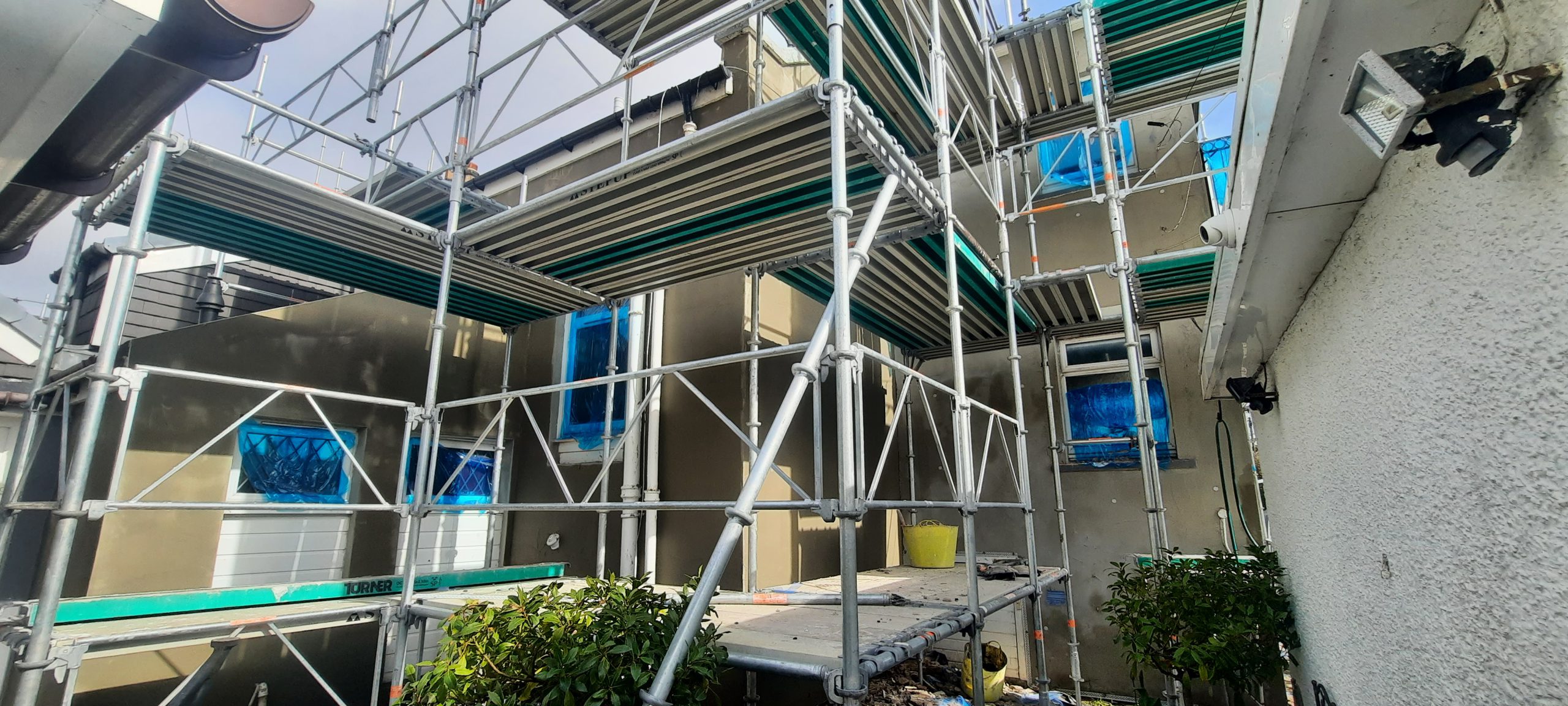 roughcast render repair on multi-level façade