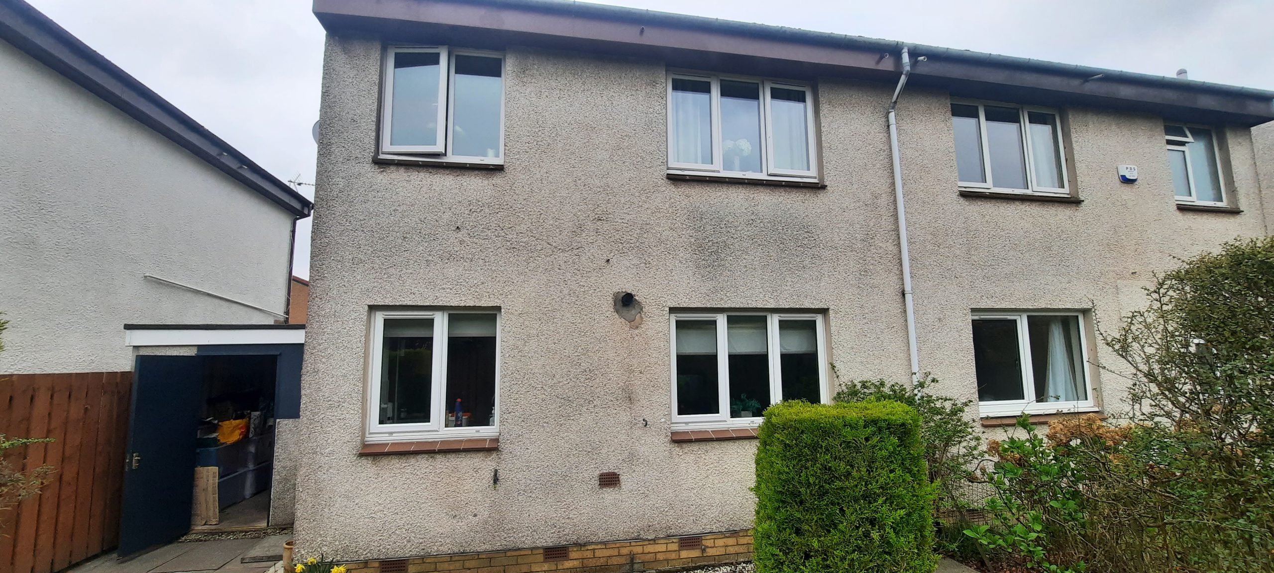 older house exterior with original roughcast render, awaiting renovation