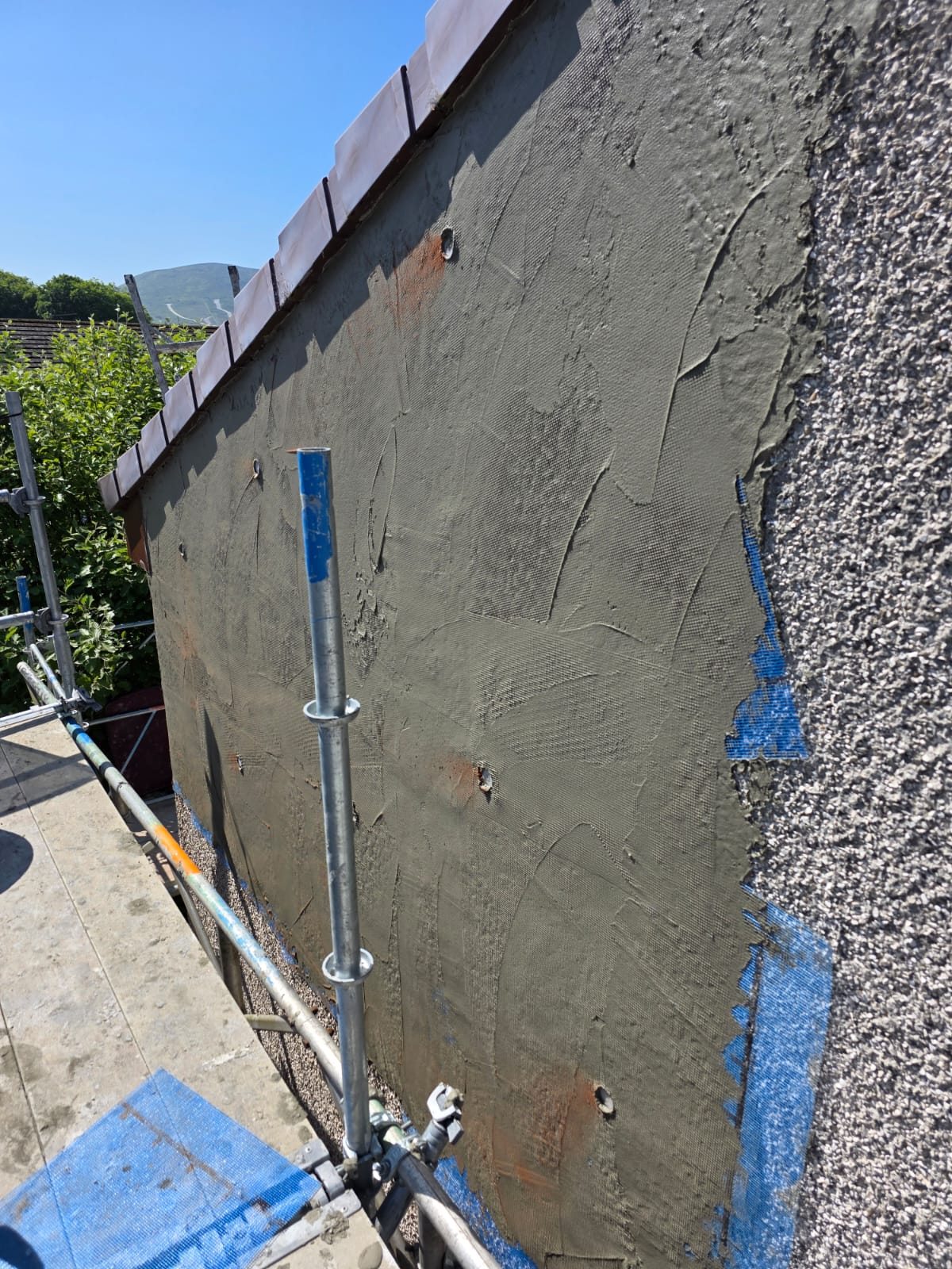 roughcast repair showing transition from old textured surface to new smooth coat