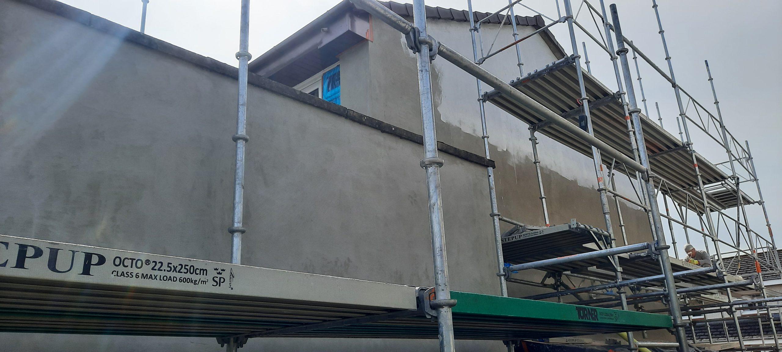 Rendering Edinburgh freshly coated gable wall prepared for finishing