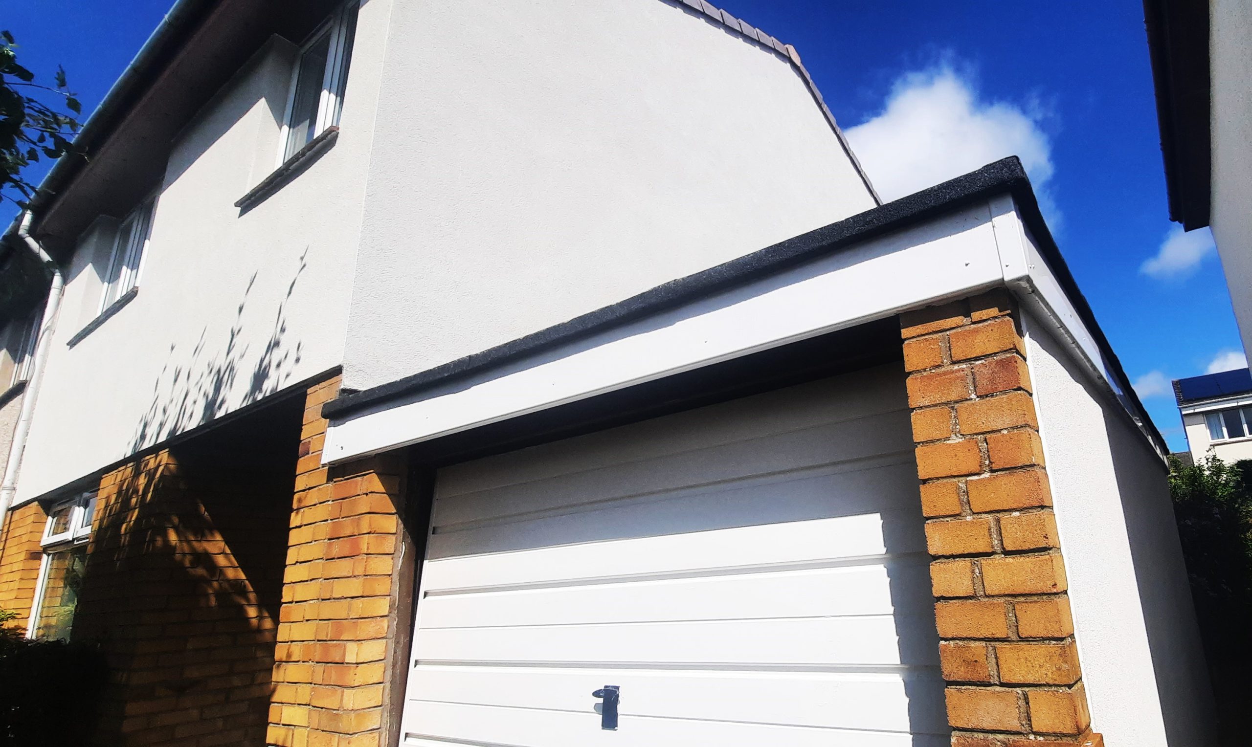 newly finished exterior wall showing quality roughcast repair above garage door