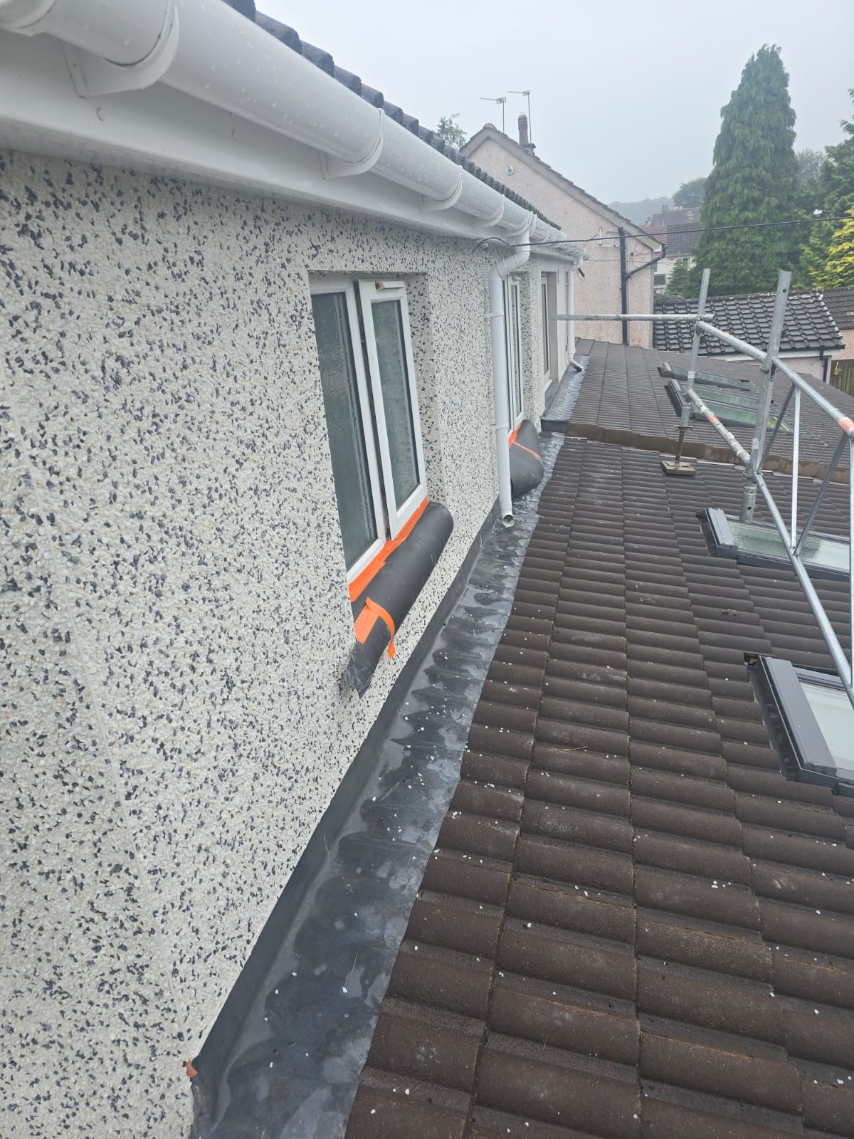 close-up of roughcast repair along upper wall section near guttering